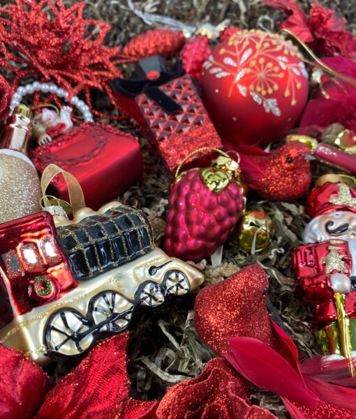 Julepynts pakke fyldt med julepynt i røde og guld farver
