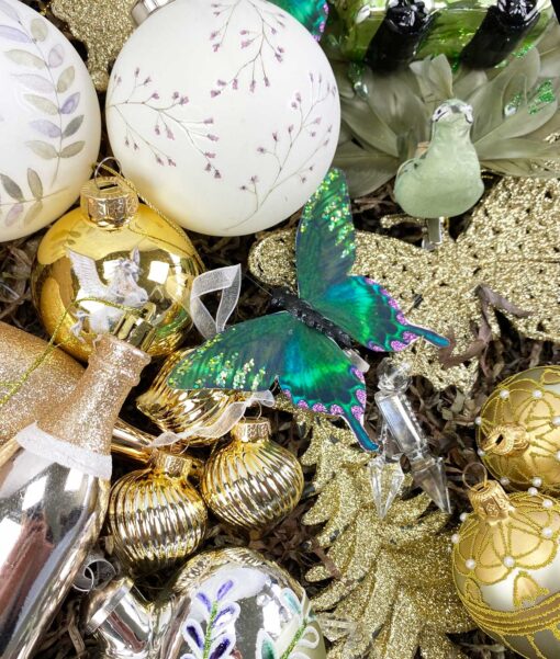 et closeup af vores julepakke med vores julepynt i grønne og guld samt hvide farver. ophæng, fugle, kugler of flasker.